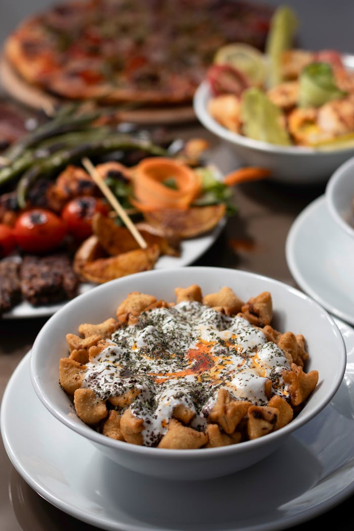A close-up of various Mediterranean dishes including pasta, grilled vegetables, and a fresh salad.