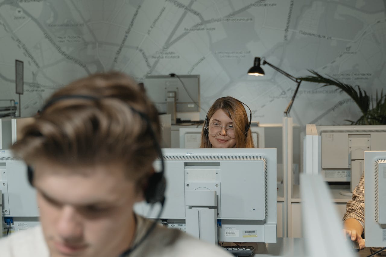 Call center employees working with computers and headsets, providing customer support.